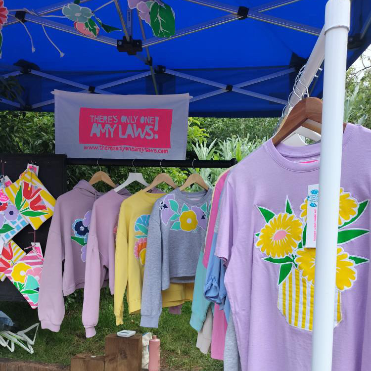 Amy Laws market stall with brightly coloured printed t-shirts