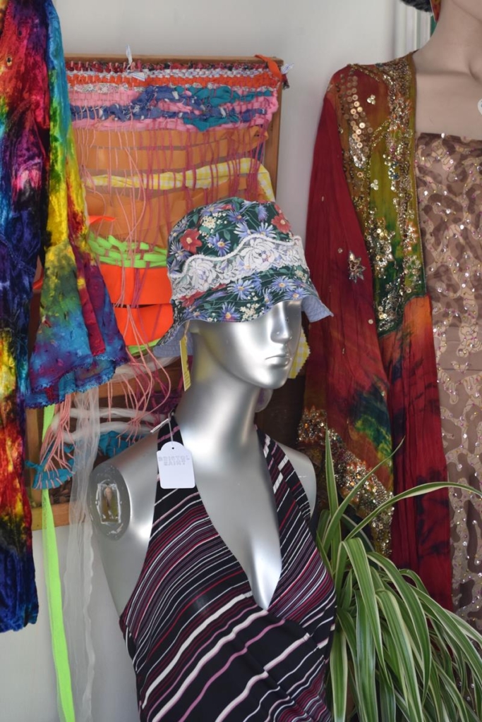 Market stall mannequin wearing quirky floral and lace hat, and 70s style top.