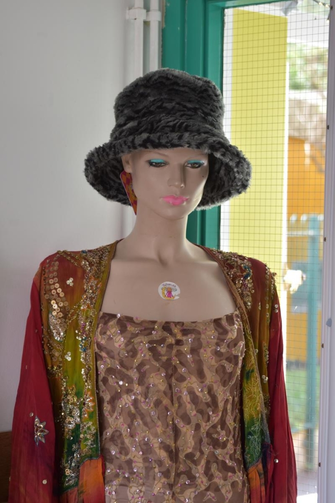 Mannequin wearing an eclectic collection of sparkly tops and faux fur hat.